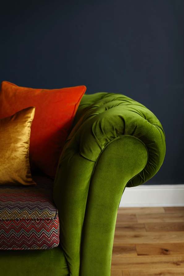 green velvet sofa, red, yellow pillows