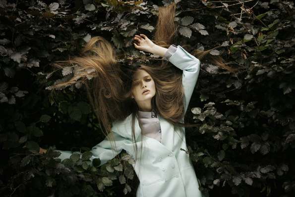 Fashion model with hair spread on leaves