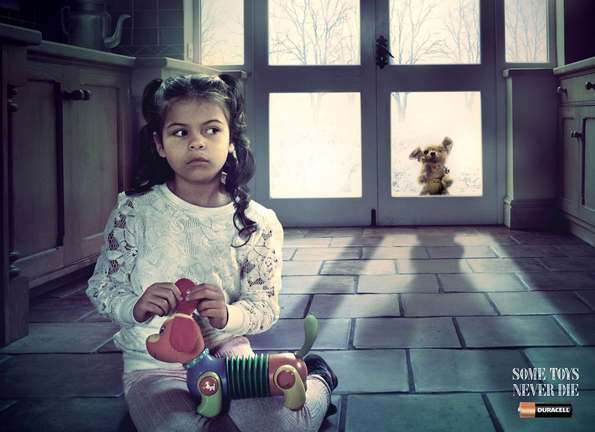 Young girl playing with toy while old toy watches from outside the door